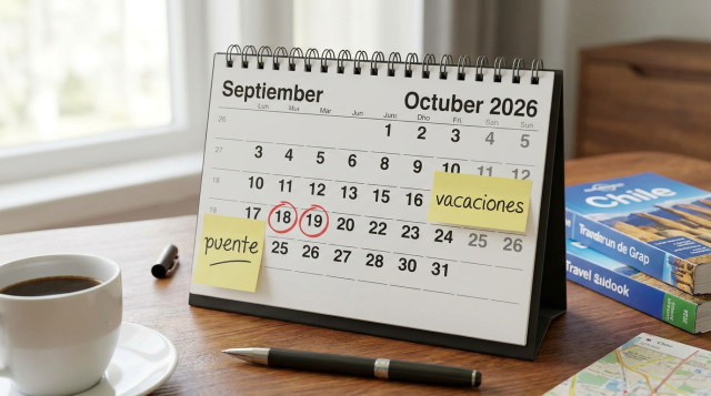 calendario de mesa abierto mostrando los meses de septiembre y octubre, con marcas rojas en 18 y 19 de septiembre y notas adhesivas con la frase 'puente' y 'vacaciones' — foco en l