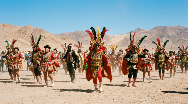 grupo de bailarines en trajes tradicionales durante la Fiesta de La Tirana, con fondo de paisaje del Norte Grande